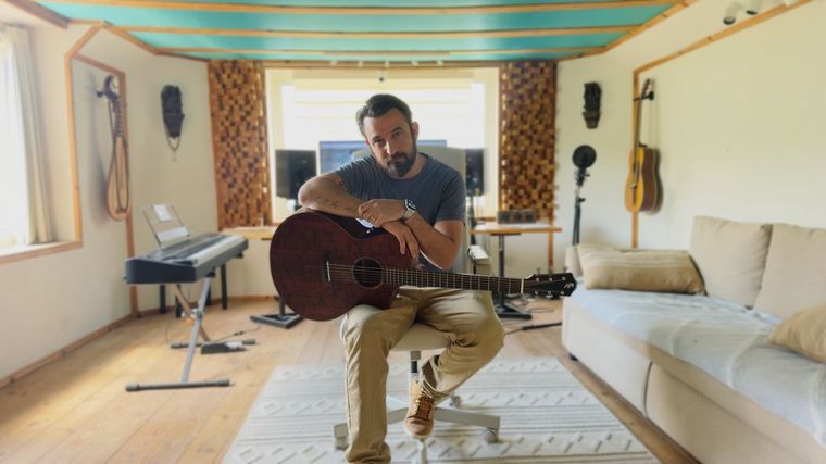 Philip Halloun with a guitar in his studio